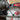 Milwaukee circular saw in use with a gloved hand, on a blurred background.